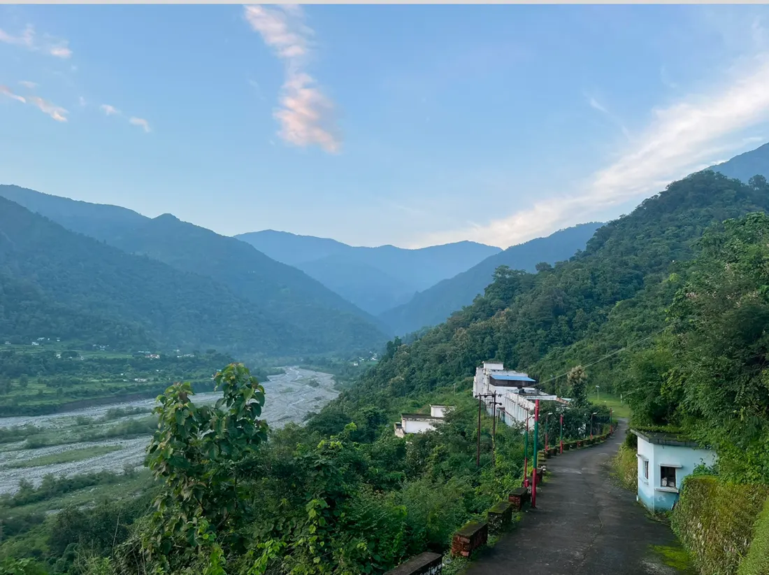 A green river valley with a road winding along a hillside